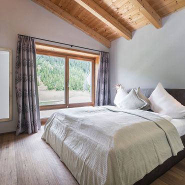 Ein Schlafzimmer mit großen Fenstern und einer Aussicht auf die Berge