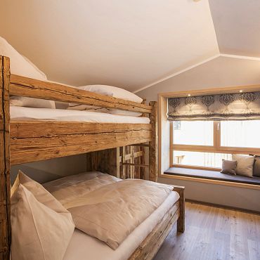 Alpegg Chalets in Waidring bei Kitzbühel_uriges Schlafzimmer mit Altholz