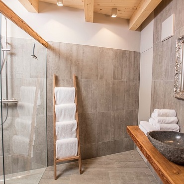 Wundervolles Badezimmer mit Dusche in den Alpegg Chalets Steinplatte Waidring