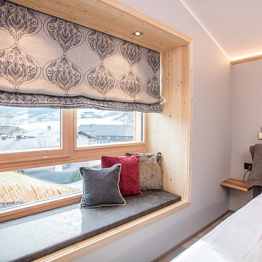 Alpegg Chalets Zimmer Steinberg mit Window Seat und Blick auf das wunderschöne Skigebiet Steinplatte