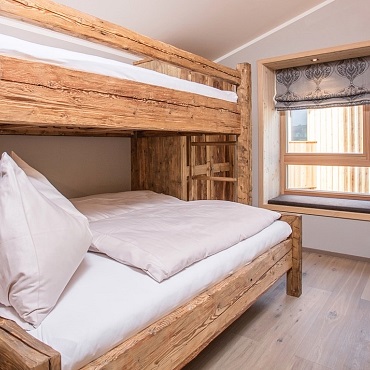 Zimmer Steinplatte mit Altholz-Bett in den Alpegg Chalets, Tirol