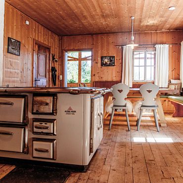 Almküche mit Holzherd und behagliche Stube